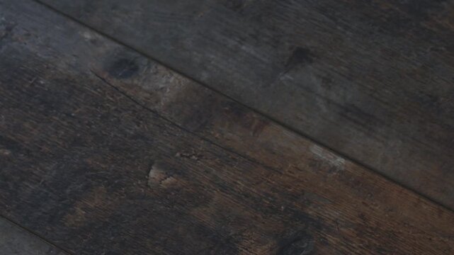 Picking up a gift box from a wooden table with a hand in a simple setup