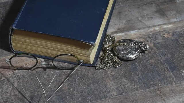 Place vintage pocket watch, old book, and glasses on table for a classic look
