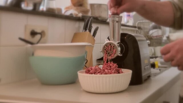 Using an electric meat grinder in the kitchen to make fresh ground meat for meals