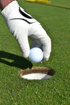 picking up golf ball