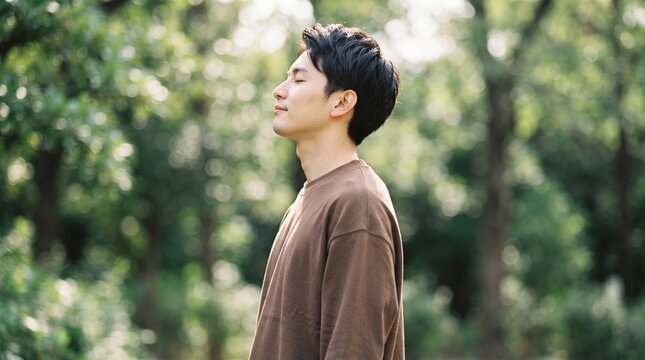 breathing exercise inhaling freedom happiness man in a peaceful forest setting, eyes closed, feeling tranquility and connection with nature, surrounded by lush greener