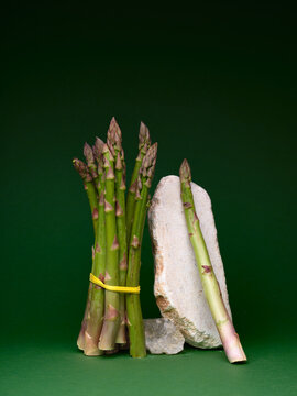 Asparagus bunch with stone and green background