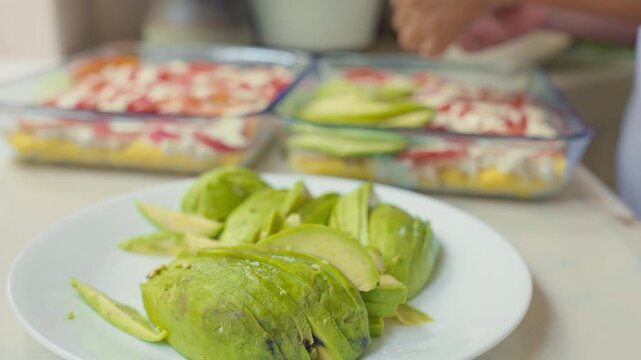 Layering avocato Slices for Peruvian Causa Rellena Preparation
