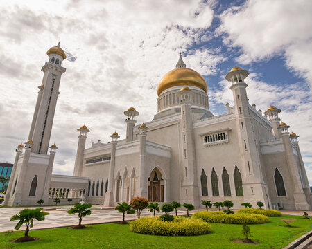 Low angle view of the Omar Ali Saifuddien Mosque with its iconic golden dome and minaret, set against a cloudy sky in Bandar Seri Begawan, Brunei