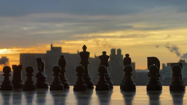 Close-up of brown wooden chess pieces on a board with a clear blue sky background.
