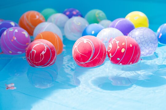 Colorful Japanese water yo-yo balloons floating on blue water surface at a summer festival