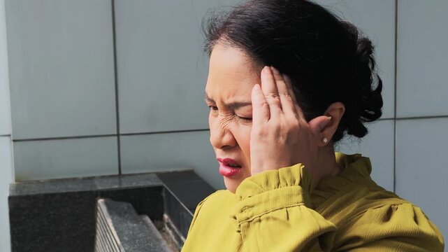 Asian senior woman having headache, concept video for stress, fatigue, sickness, health care