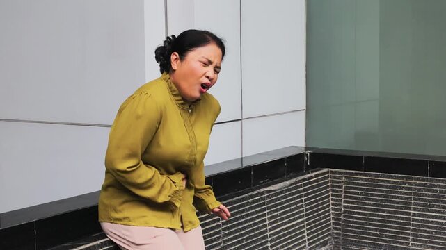 old Asian senior woman suffering from stomachache, diarrhea, constipation, food poisoning, stomach cancer concept