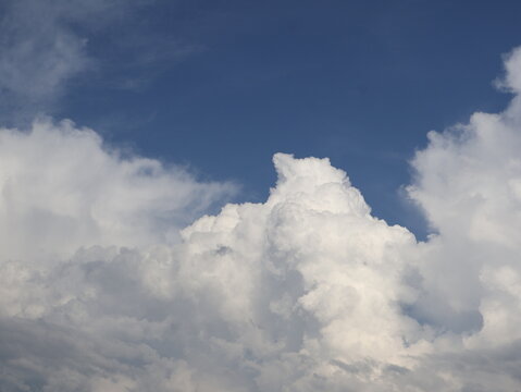 Towering white cumulus clouds against deep blue summer sky