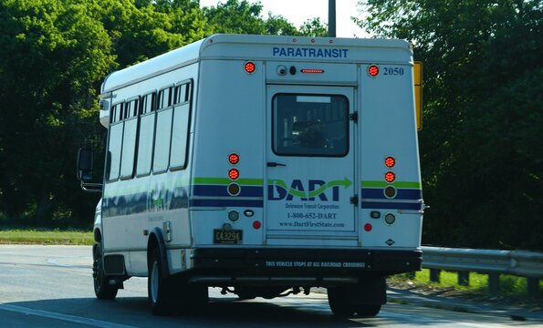 Wilmington, Delaware, U.S.A - Jul 2, 2026 - The rear view of DART Paratransit bus with lights, contact information, website, and railroad-crossing safety notice.