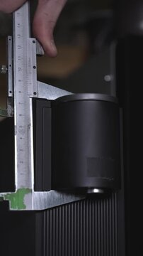 An engineer takes measurements of a coffee machine to later glue a 3D-printed dog body to it.