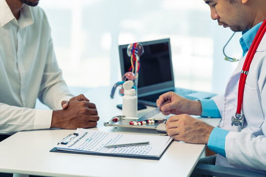 Doctor with Male Reproductive System anatomy model during a patient consultation.Close-up of a doctor explaining prostate health using an anatomical model to a patient.