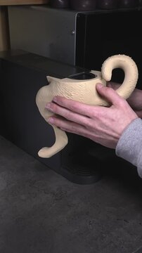 An engineer attaches a 3D-printed dog body to a coffee machine.
