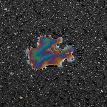 Colorful Oil Slick on Asphalt Surface with Textured Black Background