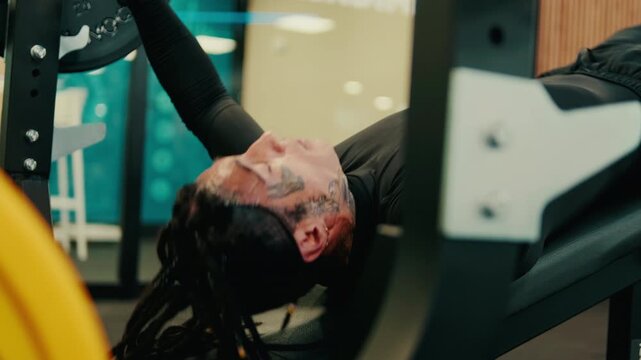 Muscular Man Bench Pressing in Modern Gym