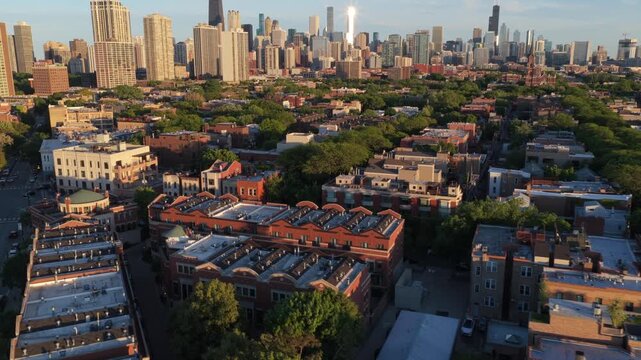 Golden hour light casting long shadows over Lincoln Park neighborhood with Chicago's iconic skyline including Willis Tower and John Hancock Center in background