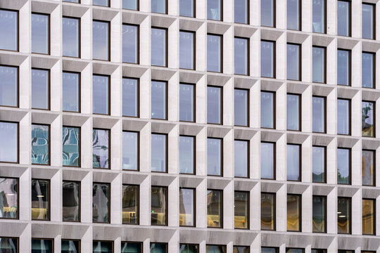 Modern architecture abstract details organize an urban building facade, where exterior windows and geometry repeat across a clean concrete grid