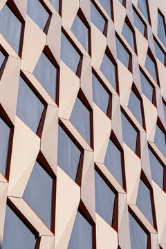 Modern architecture abstract details sharpen an urban building facade, where exterior windows and geometry repeat in a pale vertical pattern