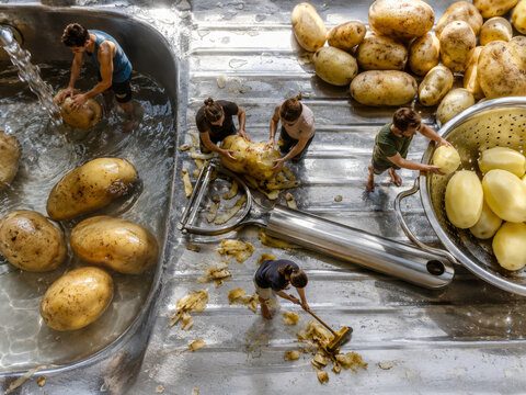 Trabajo en la cocina pelando papas en un fregadero con agua en un ambiente casero