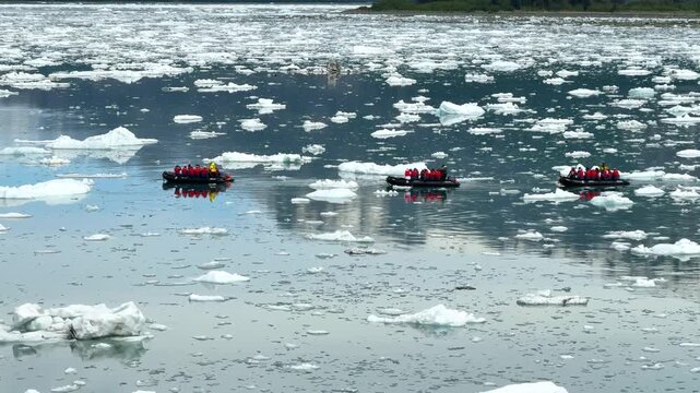 Exploring icebergs in a zodiak boat on a chilly day in the Arctic region near glacier areas