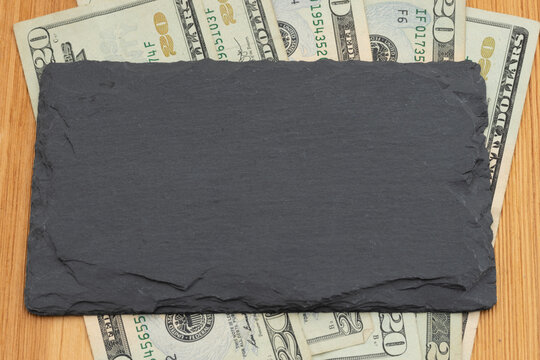 Money with blank chalkboard on wood desk