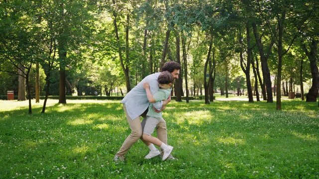 Joyful and loving father happily catches energetic little son