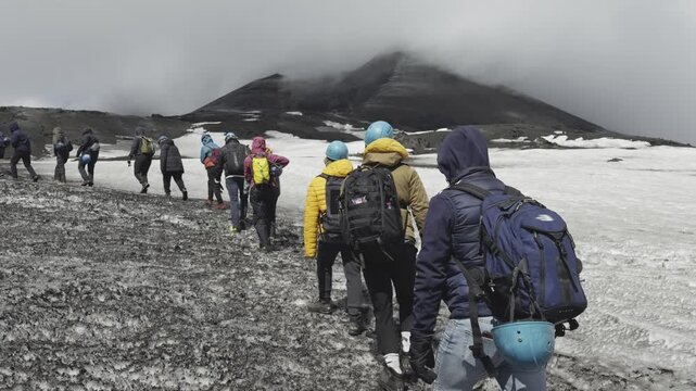 Adventurers climbing dramatic slopes of Mount Etna active volcano