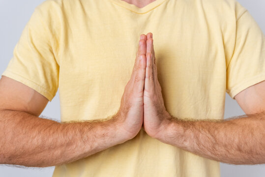 Man with hands pressed together in a prayerful namaste pose, expressing spirituality, meditation, gratitude and peaceful respect mindful greeting conveying faith, calm and devotion