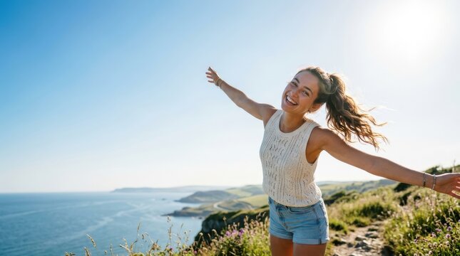 Happy young woman with arms outstretched enjoying the view of the ocean