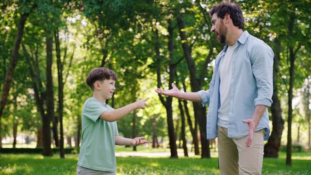 Joyful father happily plays game of rock paper scissors with son