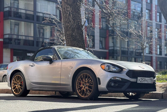 Exterior of Fiat 124 Spider I convertible silver color. Fiat Abarth 124 Spider on parking lot silver color. Italian sport car. 