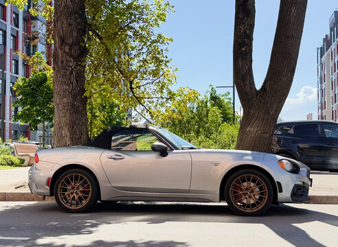 Exterior of Fiat 124 Spider I convertible silver color. Fiat Abarth 124 Spider on parking lot silver color. Italian sport car. 