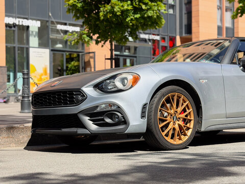 Exterior of Fiat 124 Spider I convertible silver color. Fiat Abarth 124 Spider on parking lot silver color. Italian sport car. 