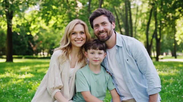 Smiling family shares warm group hug in peaceful urban park