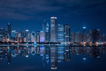 Obraz premium Chicago skyline at night with reflection in lake michigan