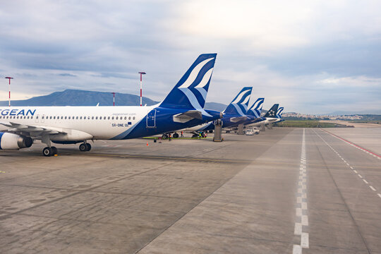 Athens, Greece - June 10, 2026: Geometric row of Aegean Airlines passenger airplanes tails lined up at airport apron parking gates