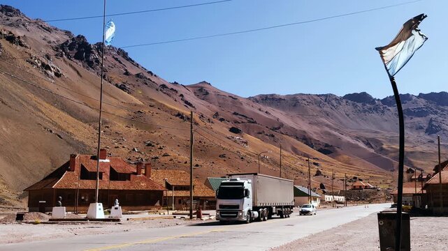 Wide Landscape of Las Cuevas Mountain Pass with Argentine Flag and Traffic, Mendoza, Argentina - 4K