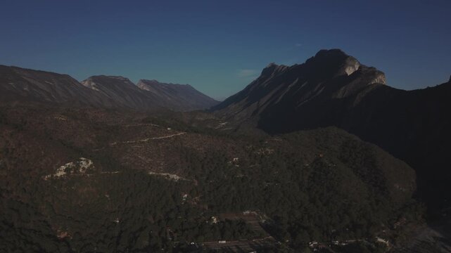 A cinematic drone aerial view of the dramatic mountain cliffs and canyon landscape of El Salto, near Monterrey, Nuevo Le&oacute;n, Mexico. Captured during golden hour,