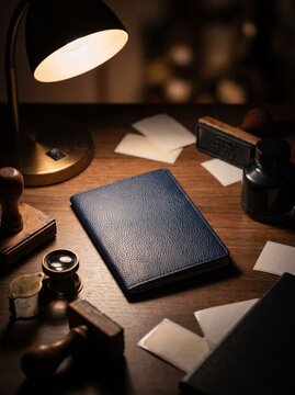 Blank blue leather document cover on vintage desk with stamps