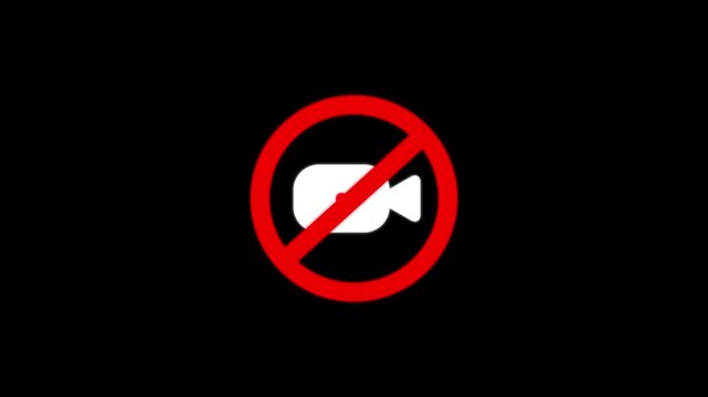 A white camera inside a red forbidden circle symbol on a solid black background representing a no recording or no filming restricted area