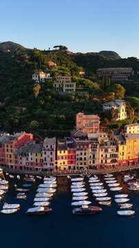 Vertical drone shot of the picturesque luxury resort of Portofino in Liguria, Italy. Drone shot of harbour with sailboats and yachts, historic colorful buildings along the Ligurian coast