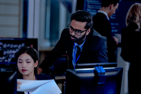 Critical AI model review. Senior data scientist leans over analyzing code output with junior engineers. Debugging complex algorithms together for optimal service performance at night.