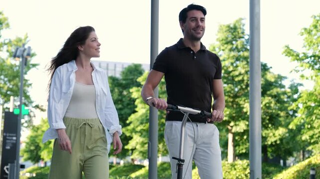 Happy young couple enjoying a sunny day walking together in a modern city park