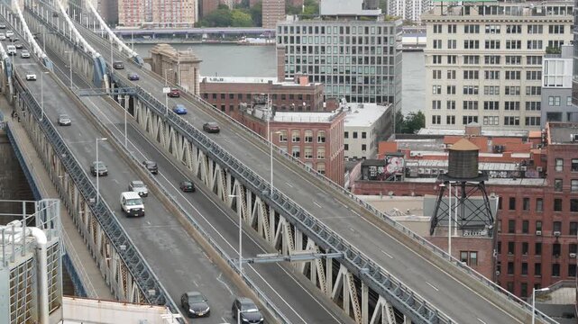 Manhattan bridge from above, rooftop in Brooklyn Dumbo, New York, United States. City traffic on transport bridge aerial view, cars on road from roof. American architecture, buildings near river.