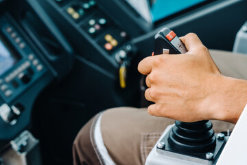 Close-up of a hand holding a joystick to control a crane.Construction concept © Alex