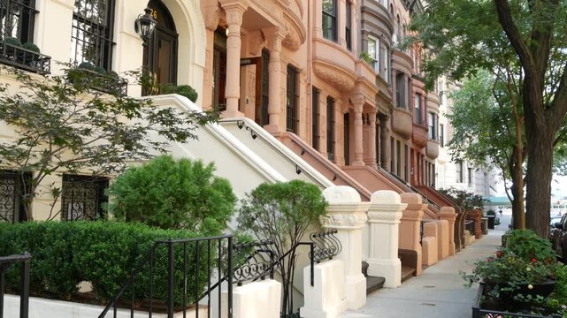 New York City townhouse buildings, brownstone row houses in Manhattan or Brooklyn, United States of America. Classic buildings on residential district street. Real estate property. Rowhouse townhome.