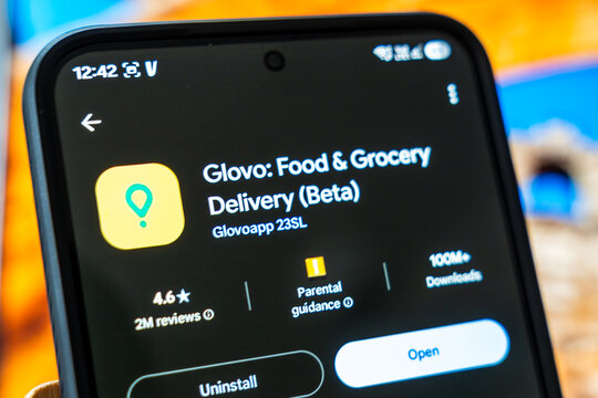 Warsaw, Poland - July 6, 2026: Close-up of smartphone screen displaying Glovo food and grocery delivery app in beta version with ratings and reviews, showcasing modern convenience technology