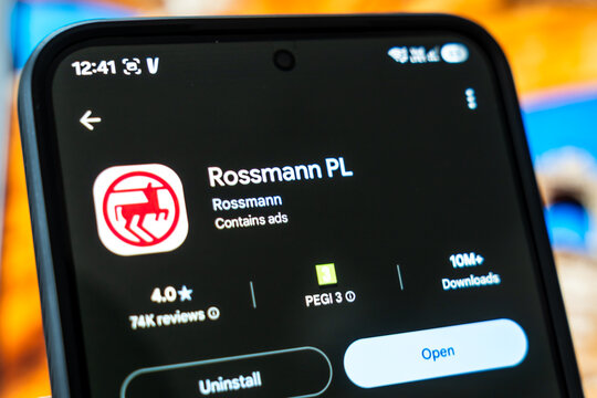 Warsaw, Poland - July 6, 2026: Smartphone displaying Rossmann PL app interface showcasing ratings and download statistics in digital environment.