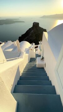 Beautiful sunset in Santorini island, Greece. White architecture with sea view. Blue sea and the blue sky at sunset. Summer travel and vacation. Vertical video
