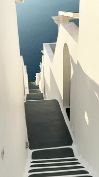 White architecture in Santorini island, Greece. Steps to the sea. Blue sea and the blue sky at sunset. Travel and summer vacation concept. Vertical video
